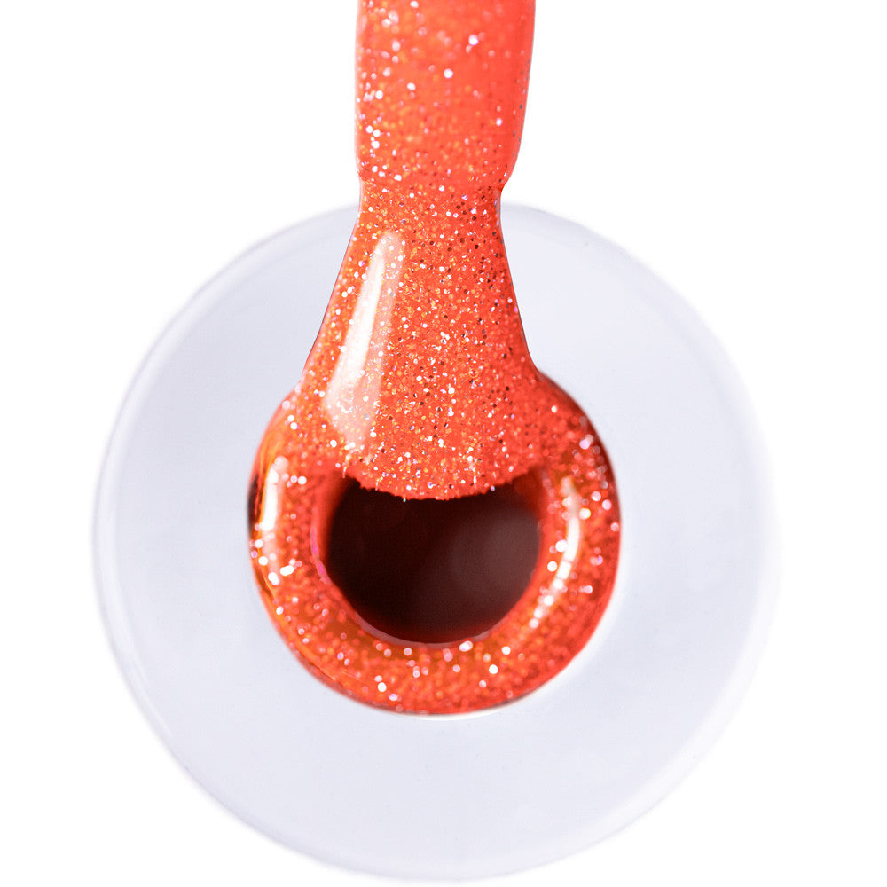 Lähikuva neonoranssista glittergeelilakasta flash-efektillä