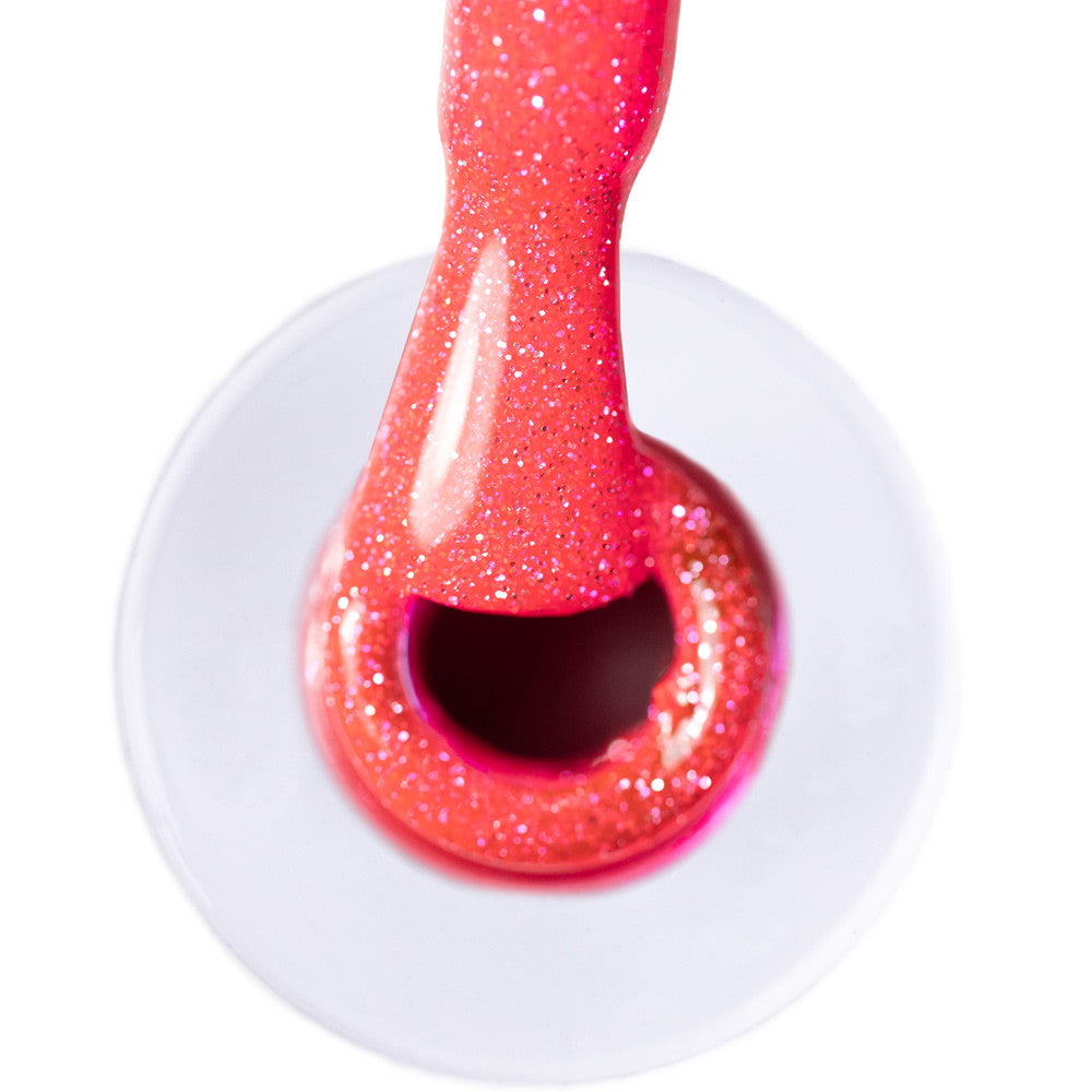 Lähikuva kirkkaasta pinkistä glittergeelilakasta flash-efektillä