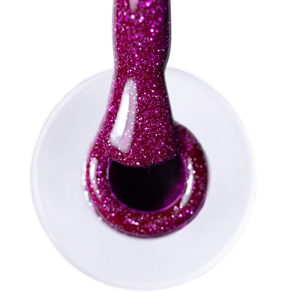 Lähikuva violetista glittergeelilakasta flash-efektillä