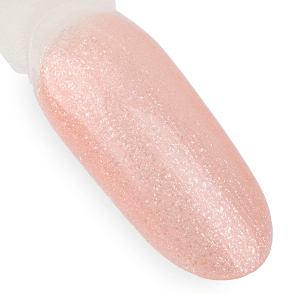 NTN Premium 63 vaaleanpunainen glittergeelilakka kynsimallissa, persikanroosa sävy ja hienojakoinen kimallus.