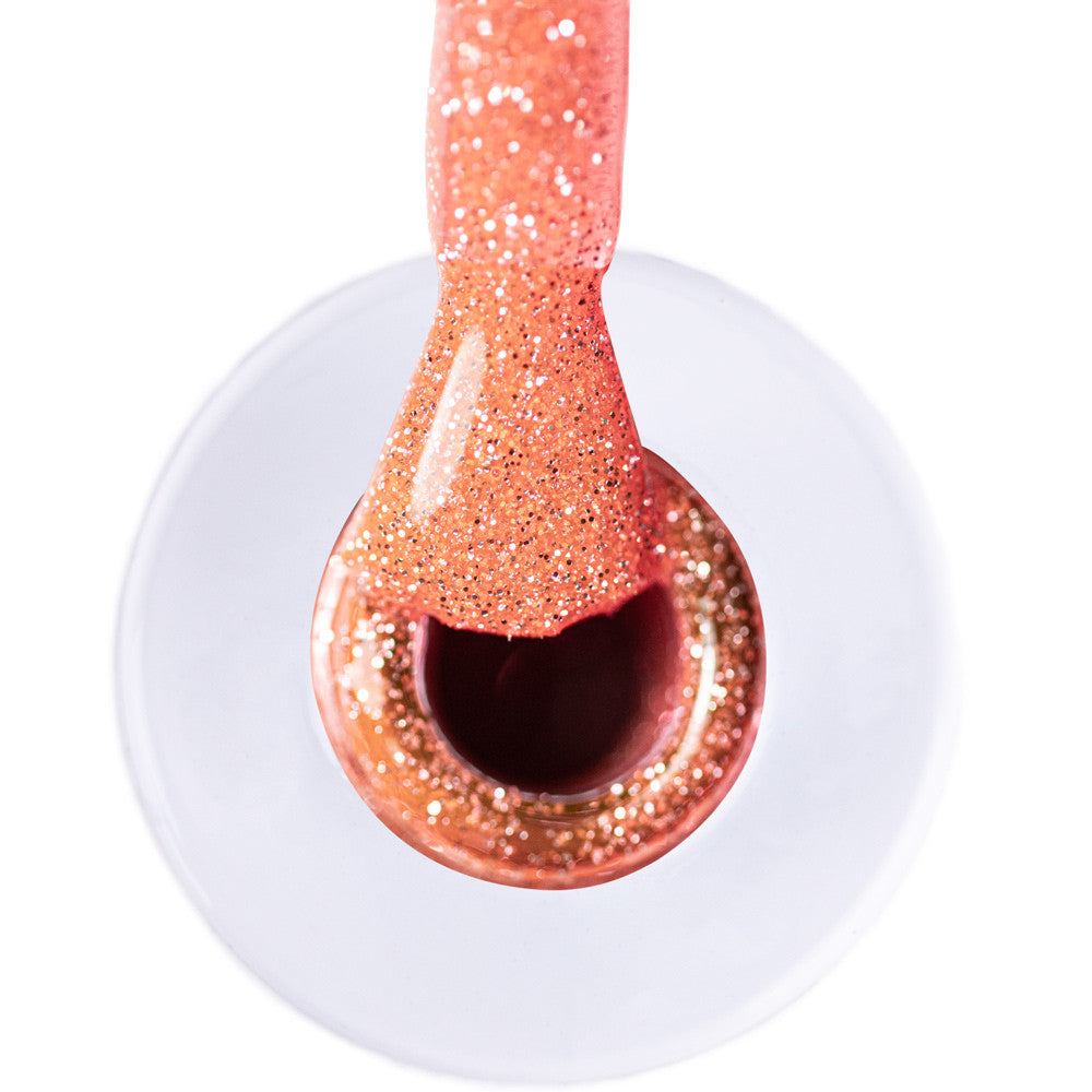 Lähikuva vaaleanoranssista glittergeelilakasta flash-efektin alla