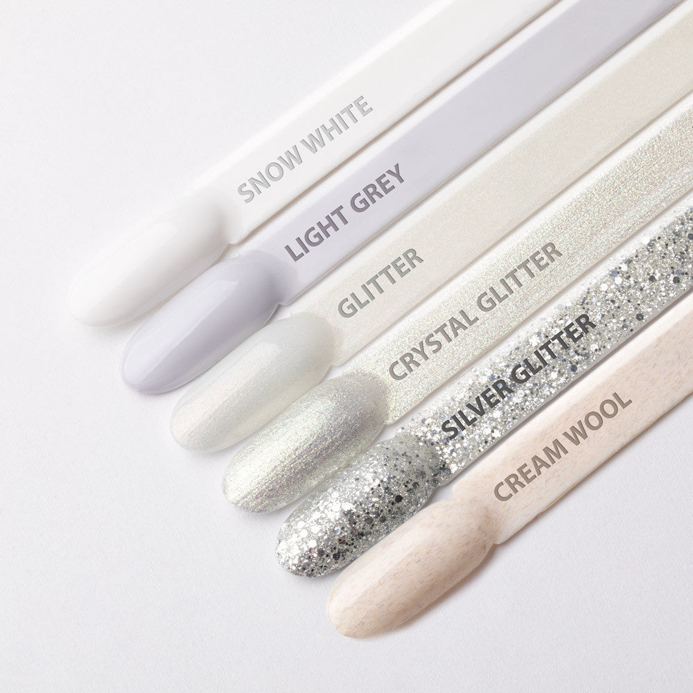 AlleLac W3 Glitter Glow helmiäisenvalkoinen glittergeelilakka valkoisten, hopeisten ja harmaiden kynsisävyjen rinnalla.
