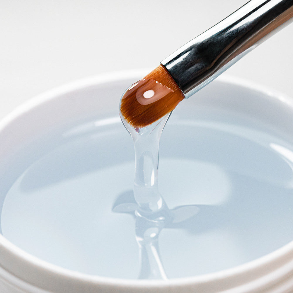 Kirkas tiksotrooppinen AlleLac Tixo Hard Builder Geelin koostumus lähikuvassa siveltimellä