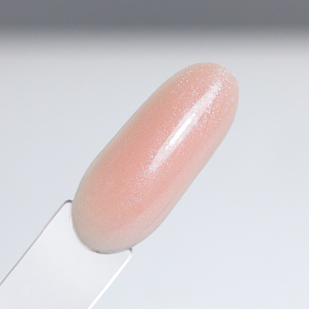 AlleLac Rubber Base 7 Peach Bling 7 g – vaalea persikanroosa kimaltava alusgeelilakka kynsimallissa.